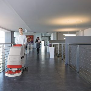 מכונת שטיפה דגם ANTEA50BT בשימוש במסדרון מודרני עם רצפת אריחים כהים ואנשים ברקע